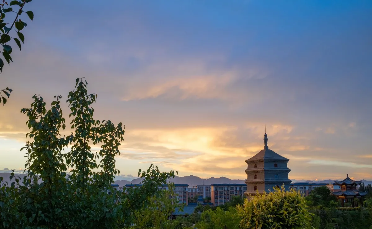 The Big Wild Goose Pagoda silhouetted against a sunset sky above the city