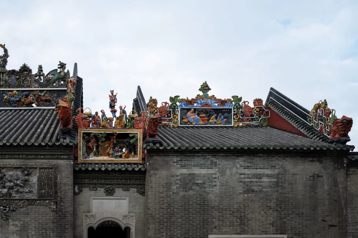 Ornate ceramic figurine friezes and dragon ridge decorations on the roof of the Chen Clan Ancestral Hall