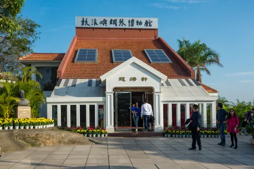 The red-roofed Gulangyu Piano Museum building with visitors gathered at its entrance
