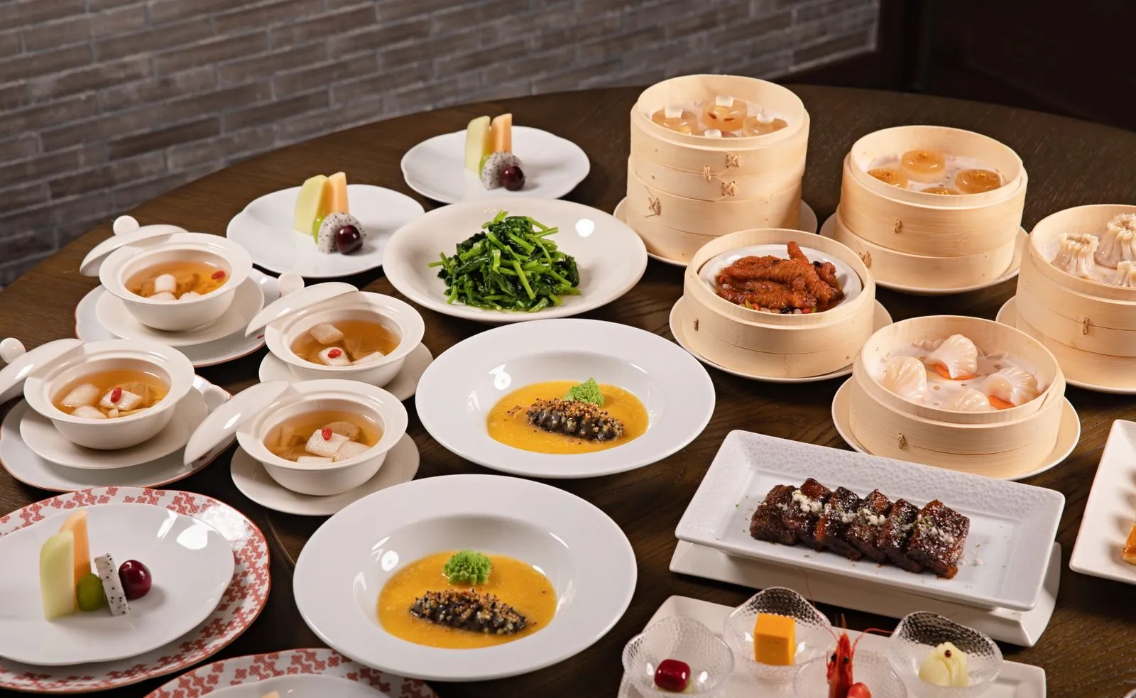 A spread of Chinese dishes including dim sum, dumplings, and stir-fried greens