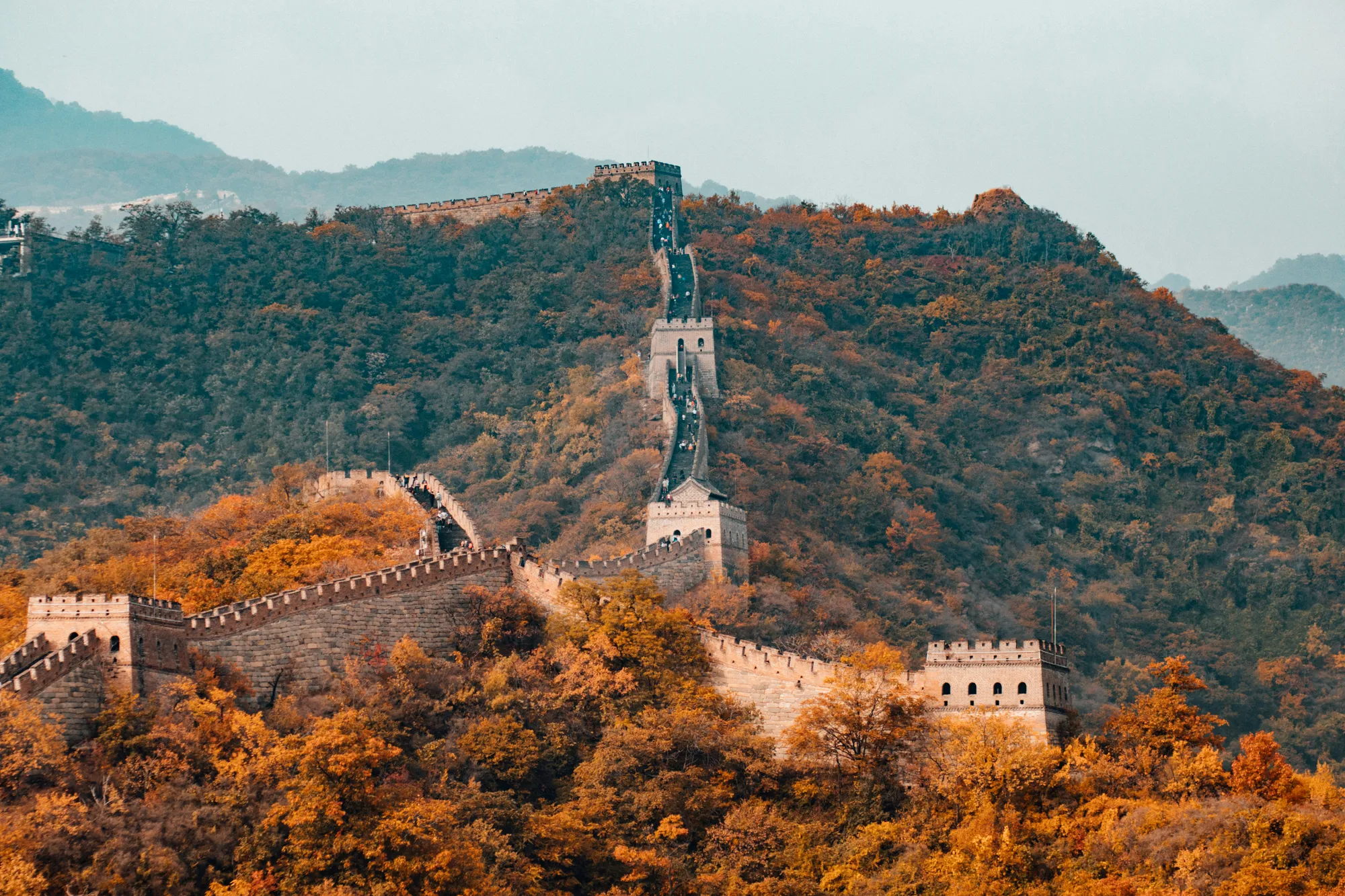 The Great Wall at Mutianyu in autumn, watchtowers rising over golden hillsides