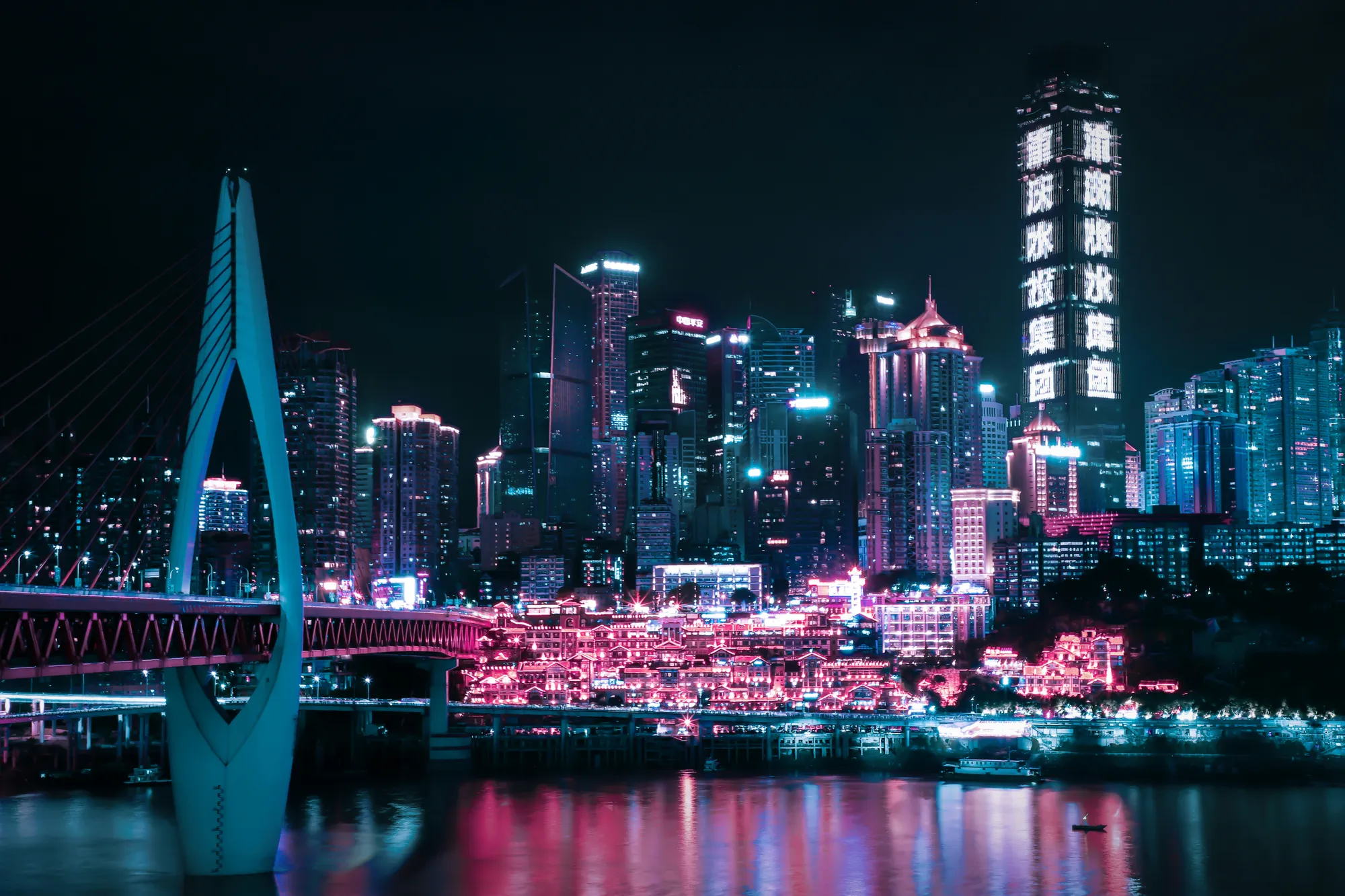 Hongya Cave glowing gold at night above the river in Chongqing