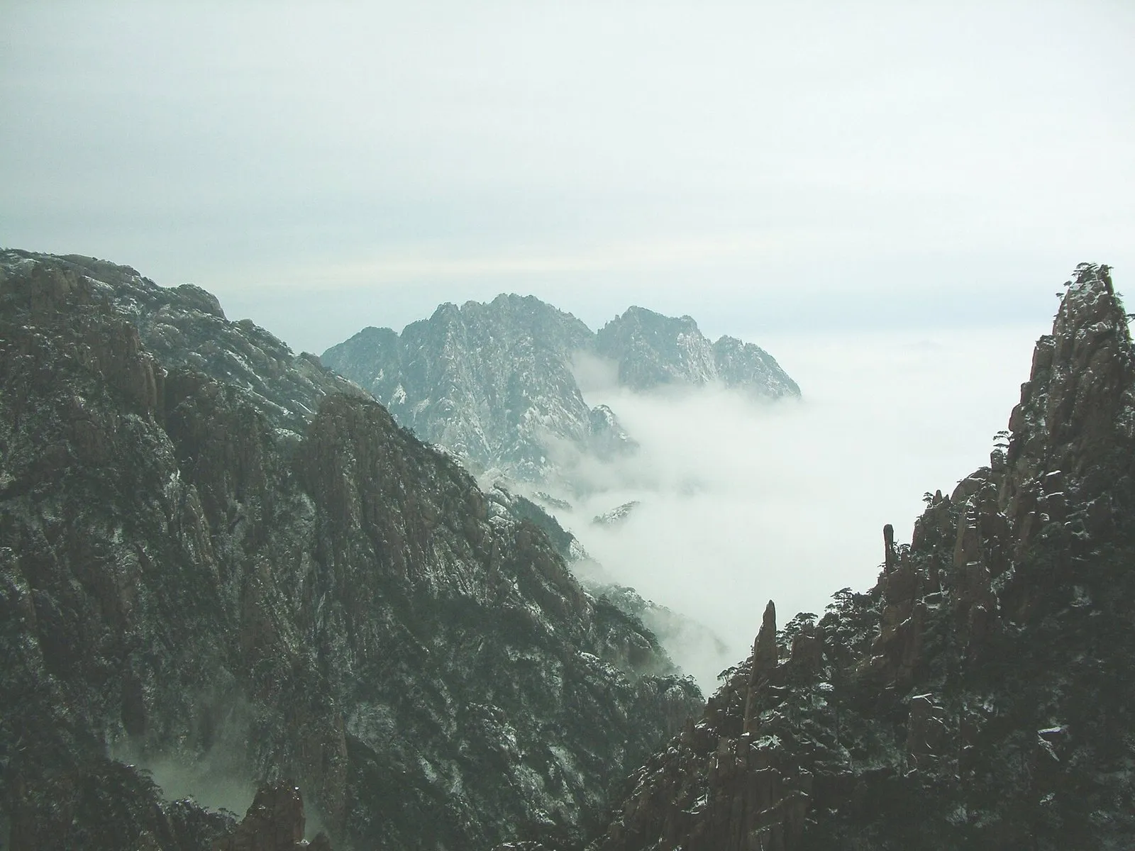 Snow-dusted granite peaks of Huangshan rising above a sea of clouds