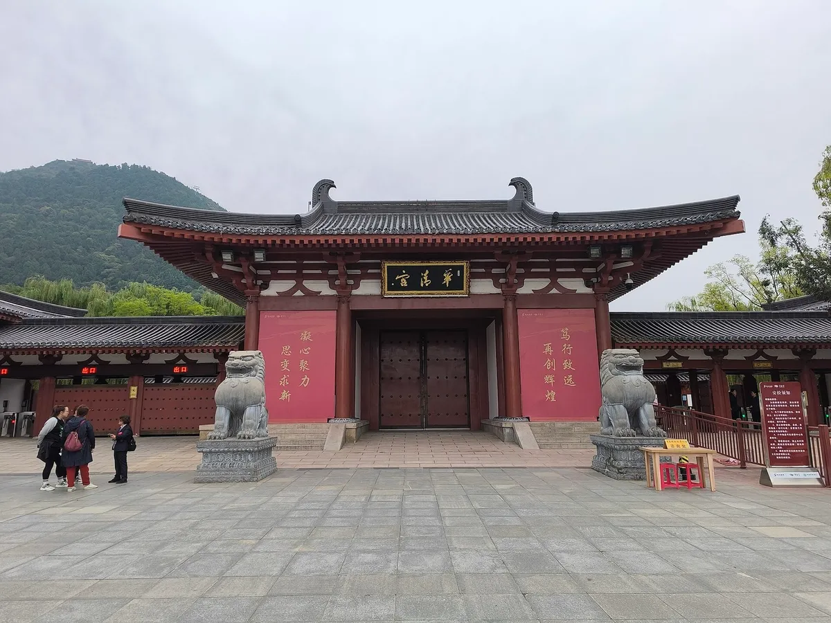 The red gate of Huaqing Palace flanked by stone lions, with the 华清宫 sign overhead