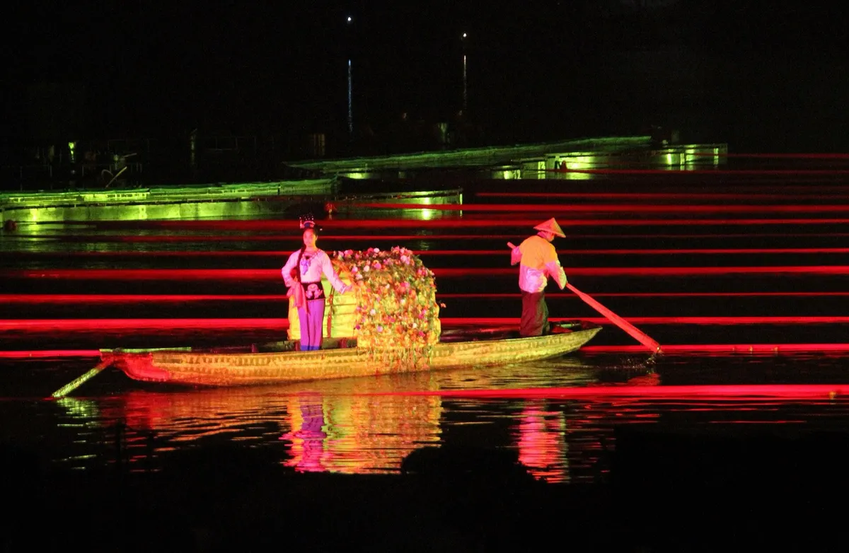 A performer on a decorated boat lit by colorful stage lights during the Impression Liu Sanjie night show