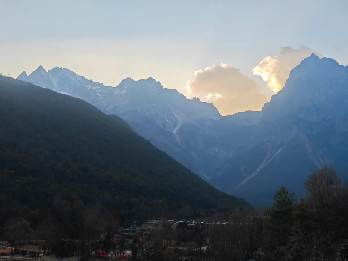 The snow-streaked main peak of Jade Dragon Snow Mountain lit by evening sun, seen from Blue Moon Valley