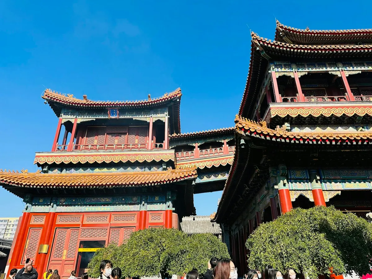 Ornate pavilions and the elevated walkway of the Lama Temple under a blue sky