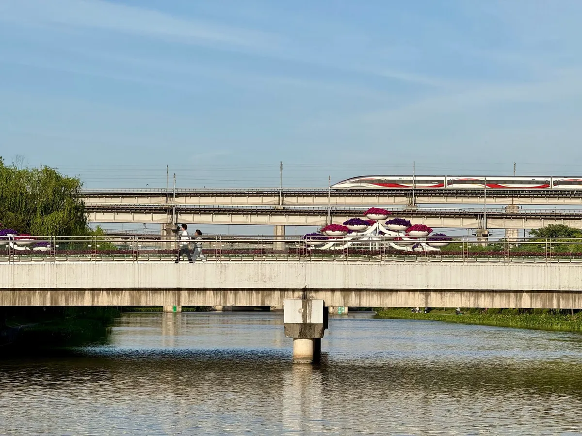 The Shanghai maglev train crossing an elevated track above a river on its way to Pudong airport