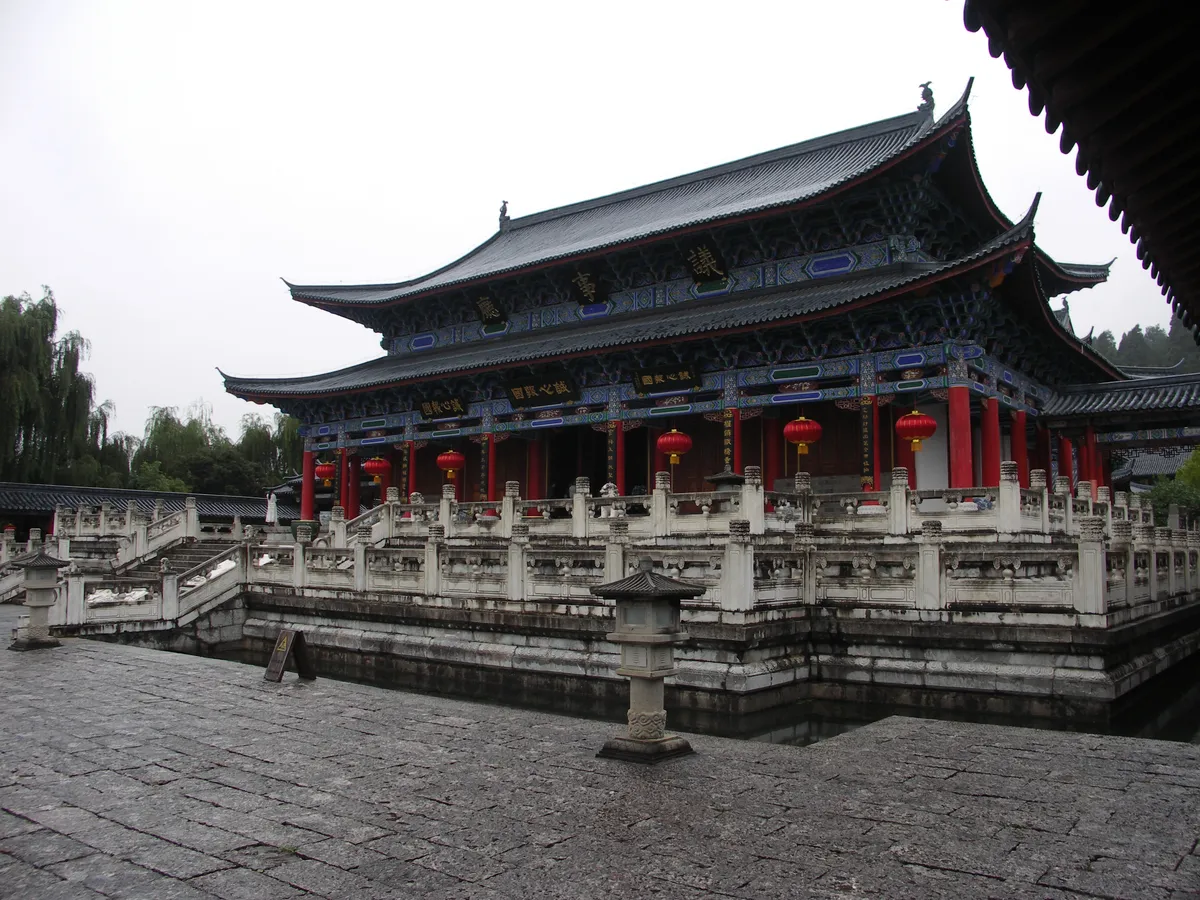 The ornate council hall of the Mu Family Mansion in Lijiang, with red lanterns hanging beneath its eaves