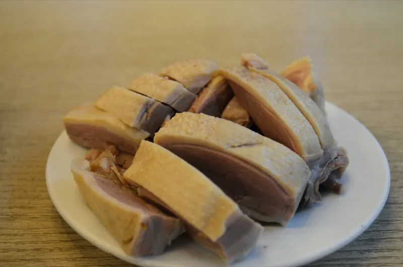 Sliced Nanjing salted duck with pale, tender meat on a white plate