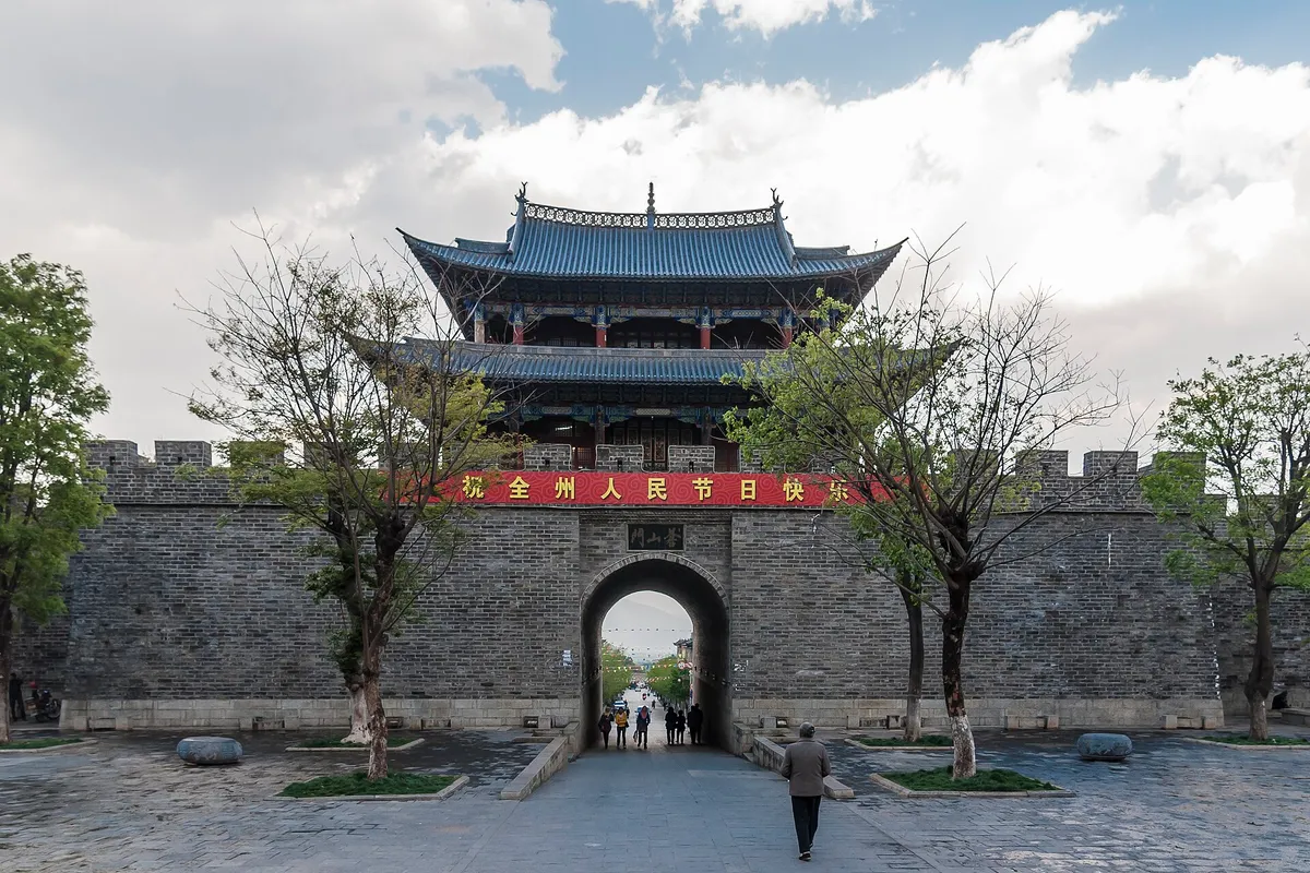 The stone West Gate of Dali Old Town backed by green Cangshan slopes