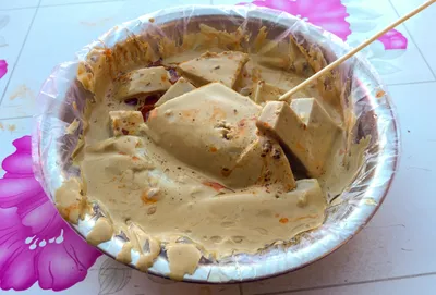 Sliced wantuo buckwheat rounds in a bowl of savory dressing, skewered with a toothpick