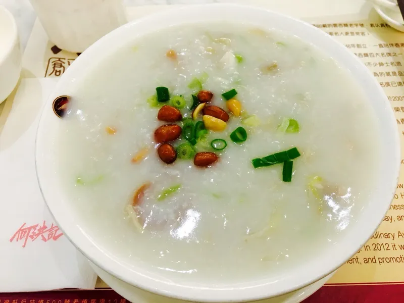 A bowl of white congee topped with peanuts and scallions, Cantonese sampan congee