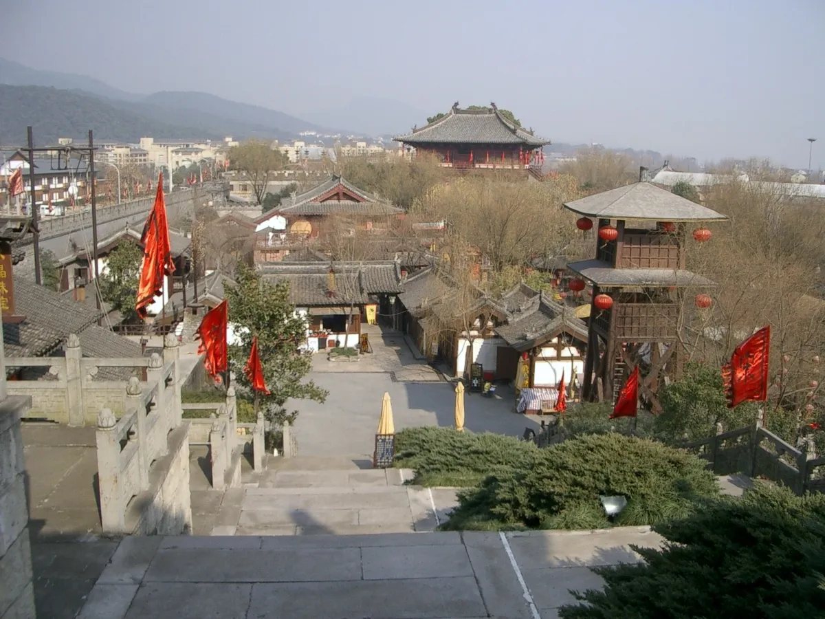 Traditional tiered rooflines and red banner flags at the Song Dynasty Town theme park in Hangzhou