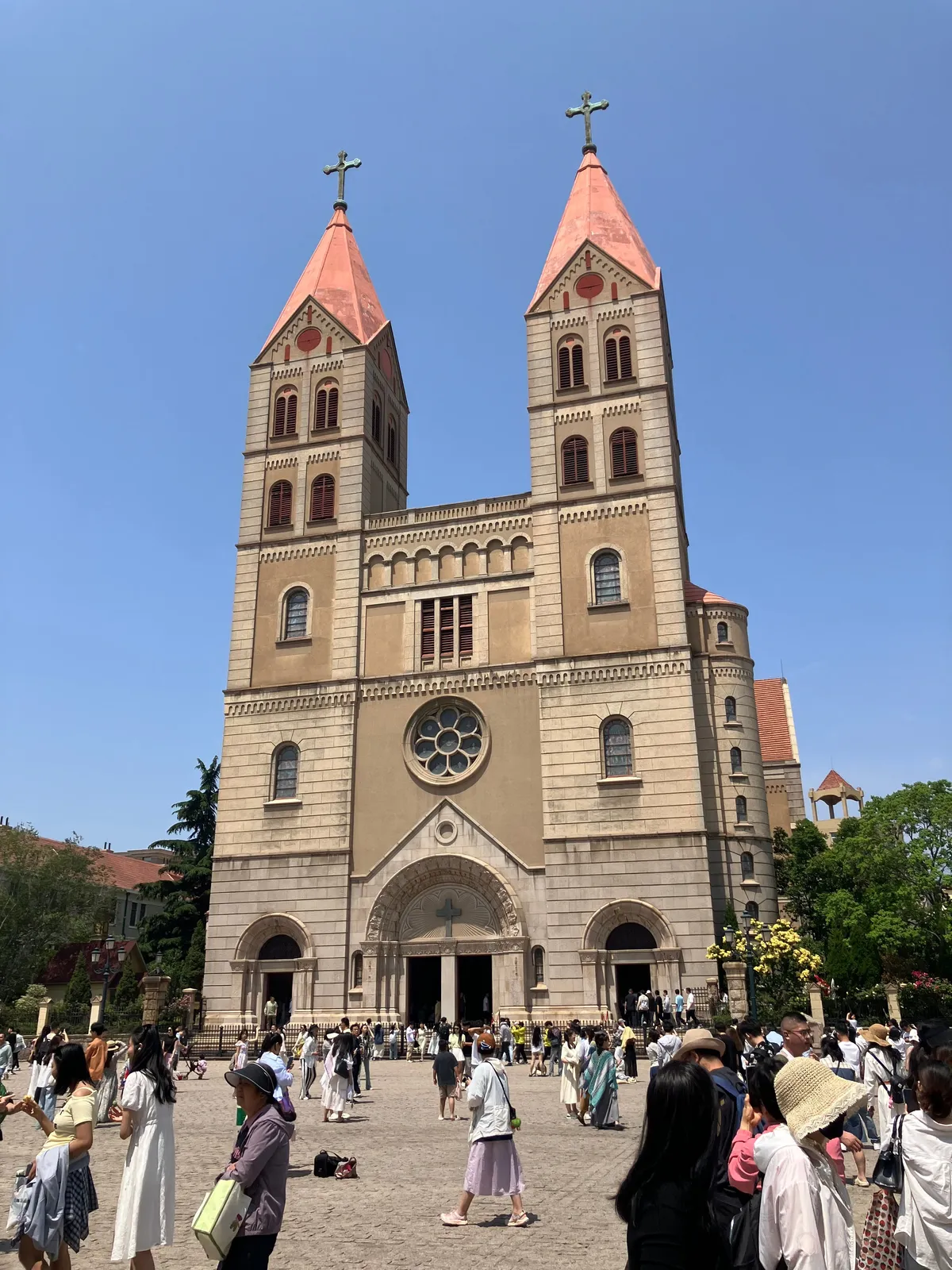 The twin pink-roofed Gothic spires of St. Michael's Cathedral in Qingdao against a clear sky