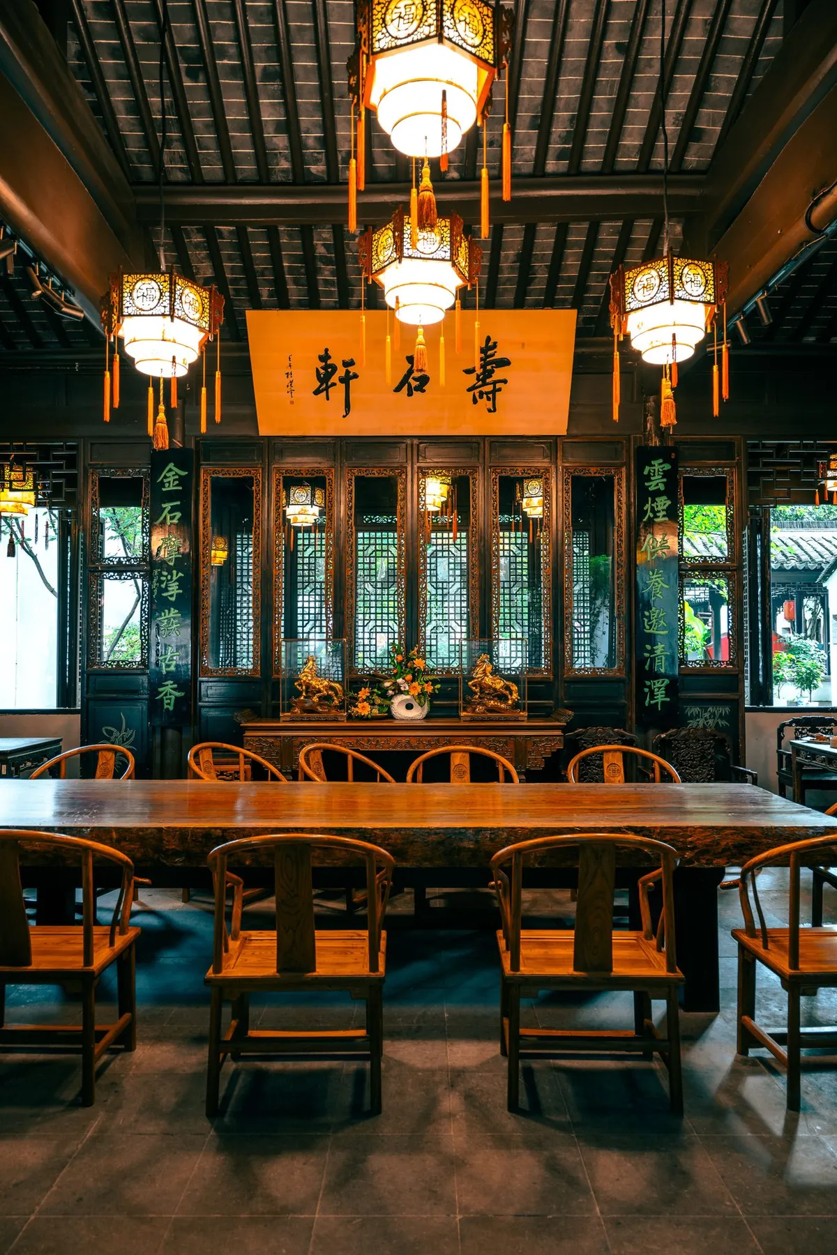 An ornate traditional Chengdu tea room interior with carved wood screens, hanging lanterns, and calligraphy
