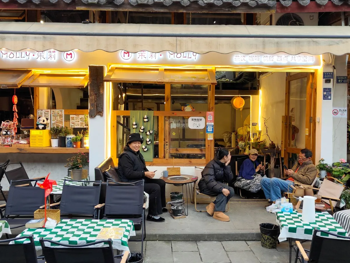 Locals relaxing with tea at outdoor tables outside a Chengdu teahouse
