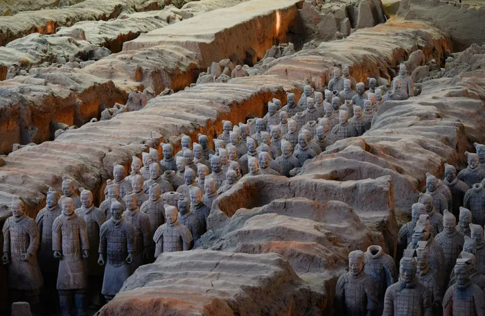 Rows of individually detailed Terracotta Army soldiers in an excavation pit