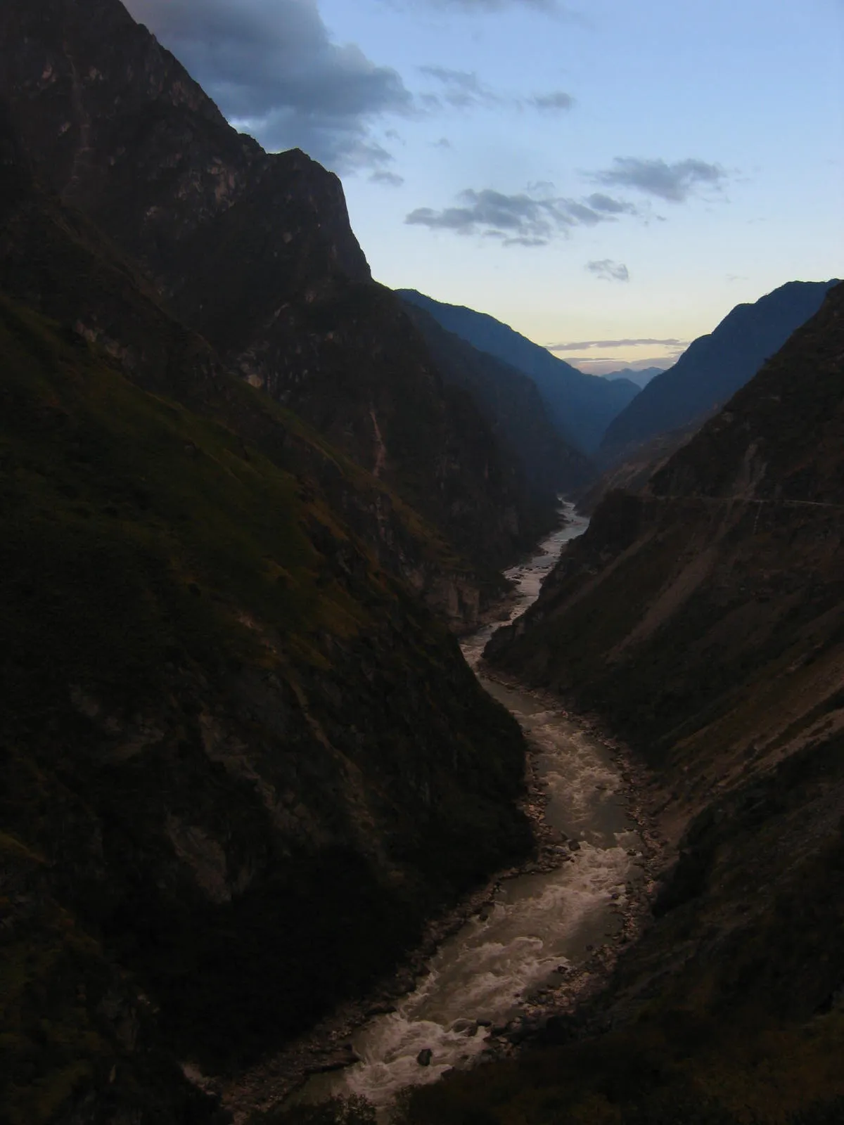 The Jinsha River rushing through the steep, dusk-lit walls of Tiger Leaping Gorge