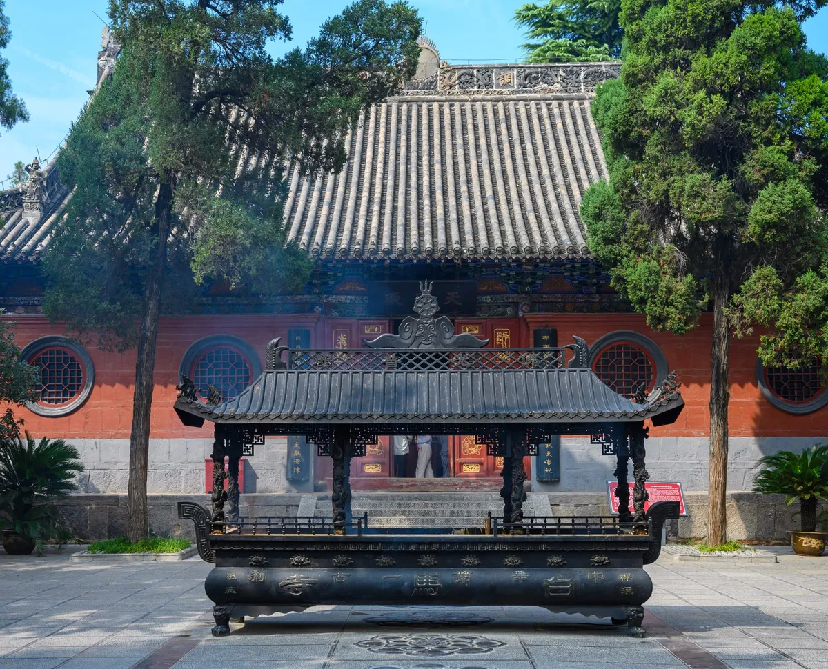 A temple courtyard with an incense pavilion in front of the main hall at White Horse Temple