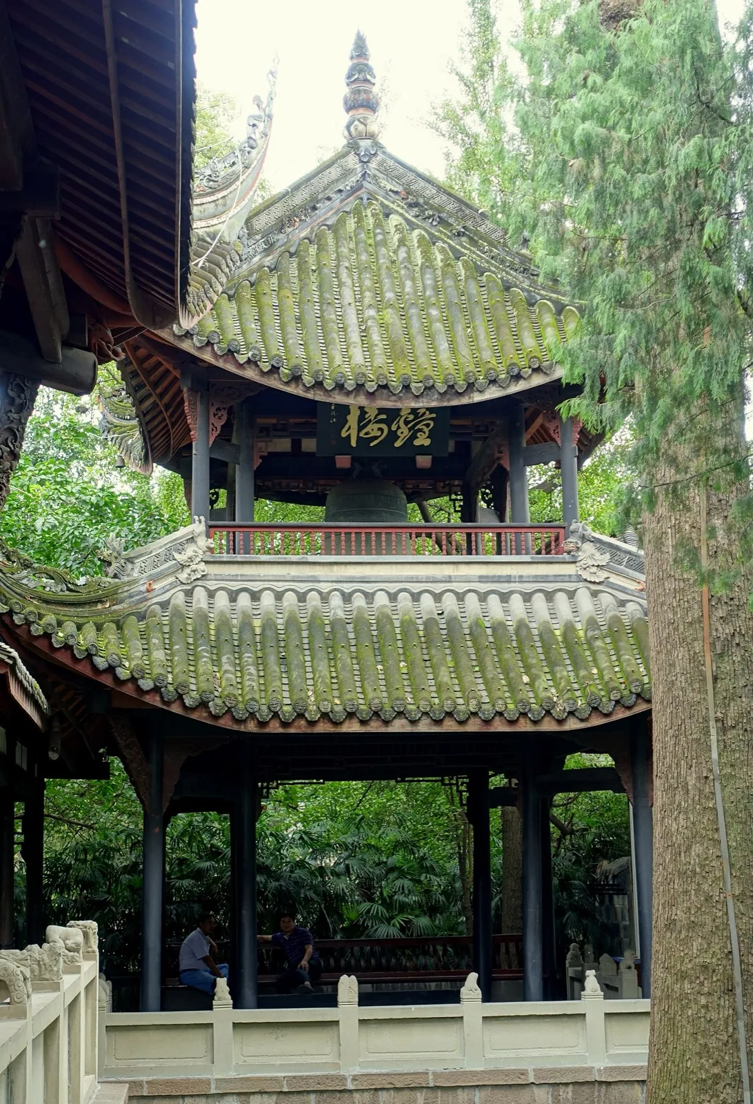 A moss-roofed pavilion with a bell inside the Wuhou Shrine grounds