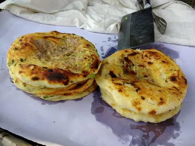 A round golden Xizhou baba flatbread with a crisp layered crust