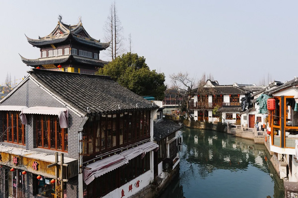 Canal-side pagoda and traditional buildings reflected in the water at Zhujiajiao